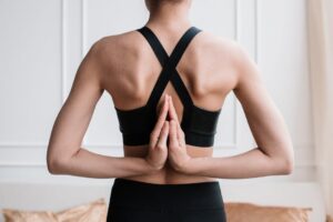 Close-up of a woman practicing the paschima namaskarasana yoga pose indoors.